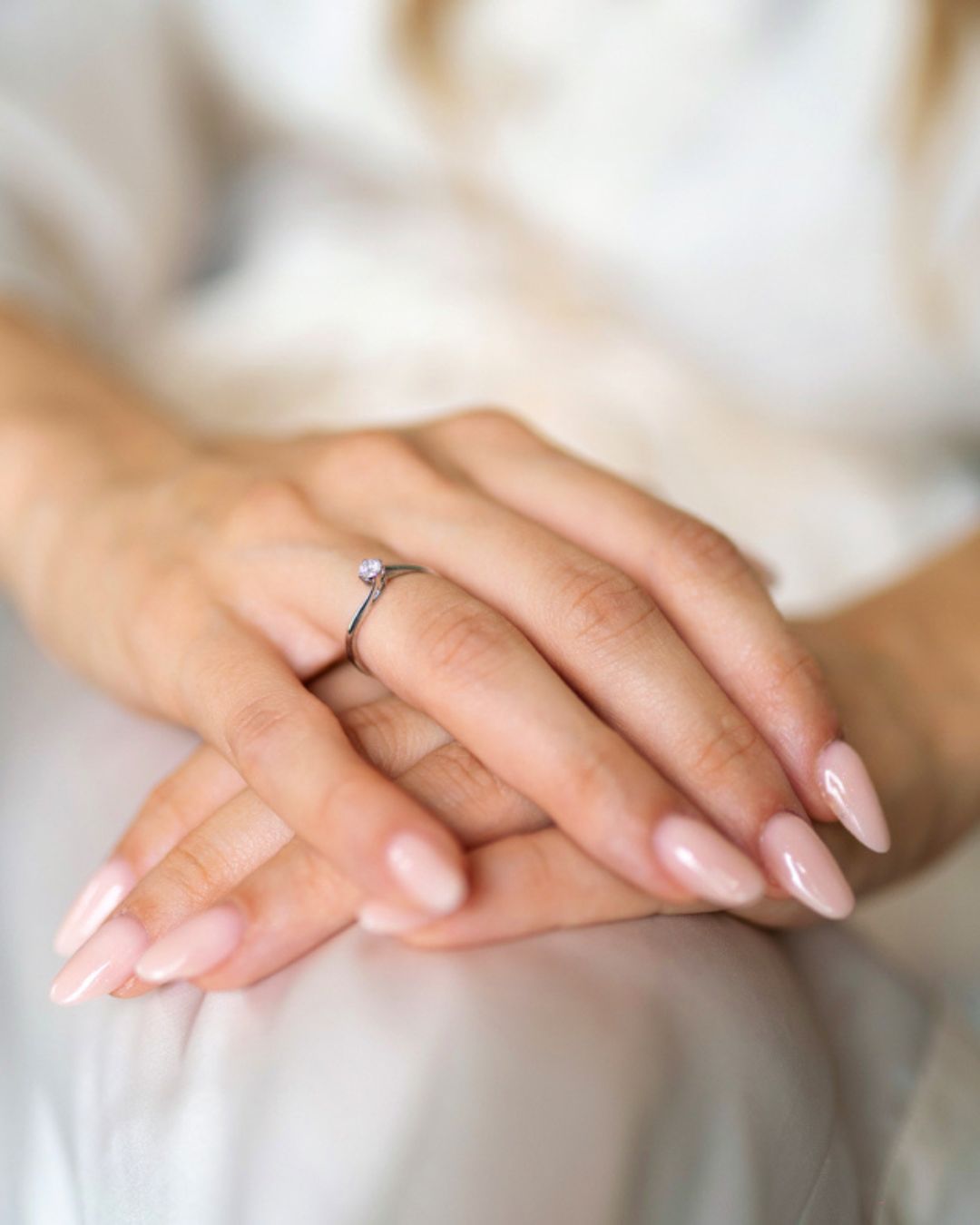 Mani della sposa con anello di fidanzamento e unghie curate color nude