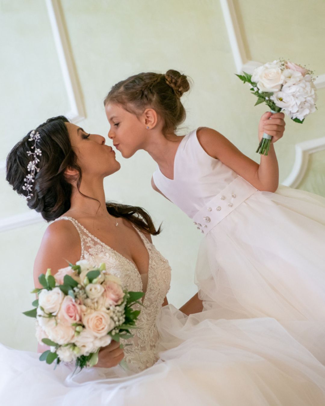 La sposa e una damigella bambina con bouquet in mano