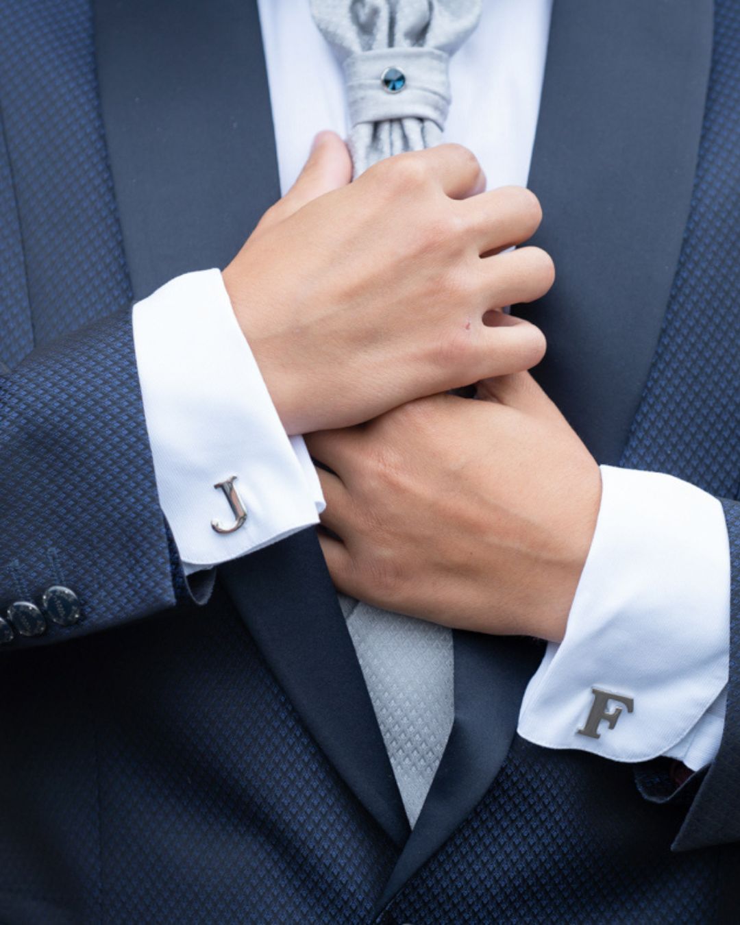Gemelli con iniziali sulle maniche della camicia dello sposo durante i preparativi di matrimonio