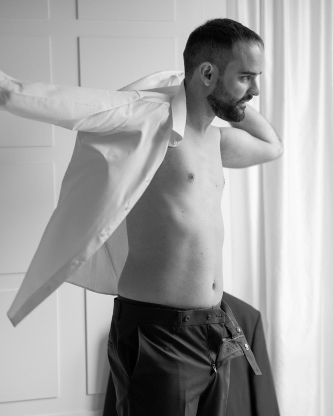 Lo sposo mentre indossa la camicia durante i preparativi del matrimonio