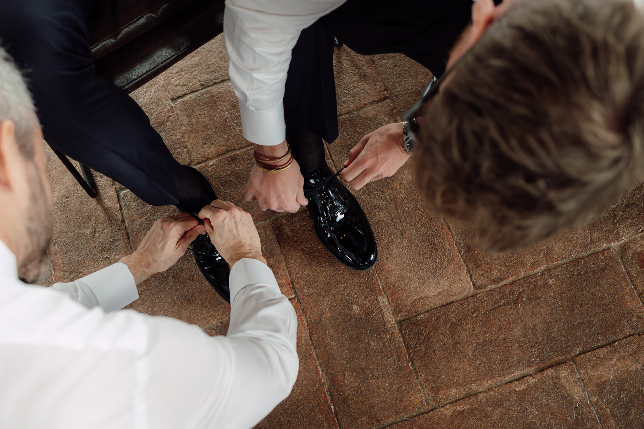 Lo sposo viene aiutato dagli amici a prepararsi per la cerimonia, momento di condivisione e amicizia prima del sì.