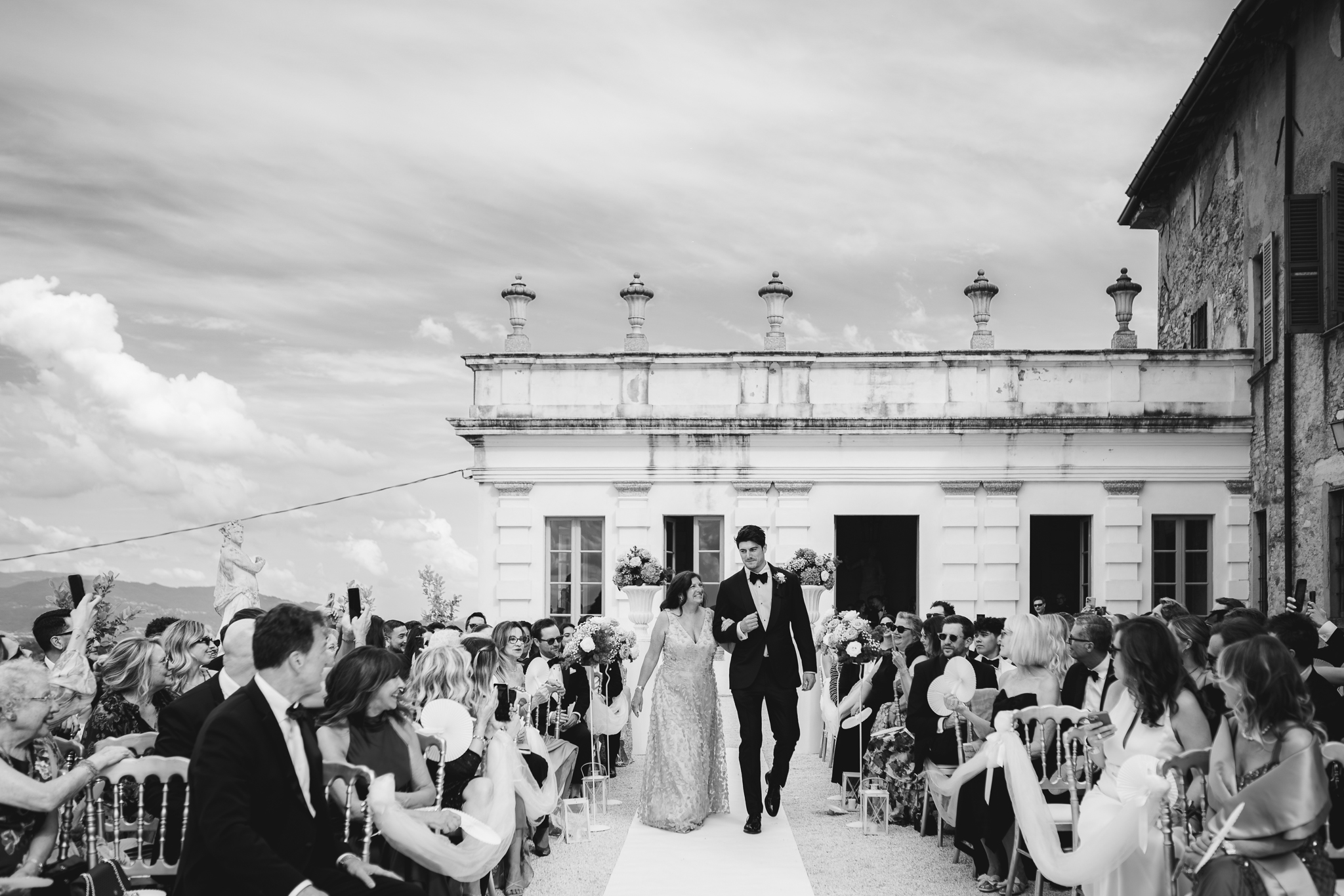 Lo sposo Conrad entra accompagnato dalla madre durante la cerimonia, circondato da sorrisi e affetto.