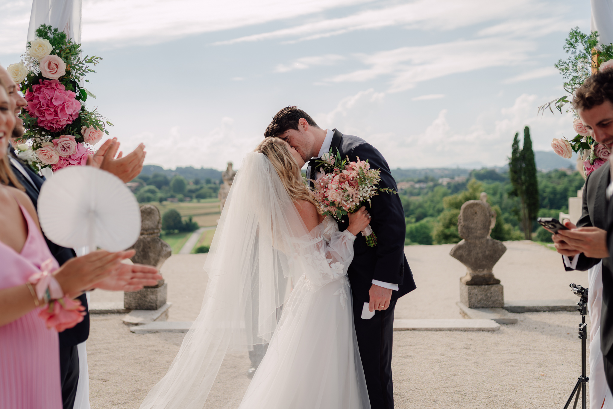 Beatrice e Conrad si scambiano il primo bacio dopo il sì, con il panorama sullo sfondo.