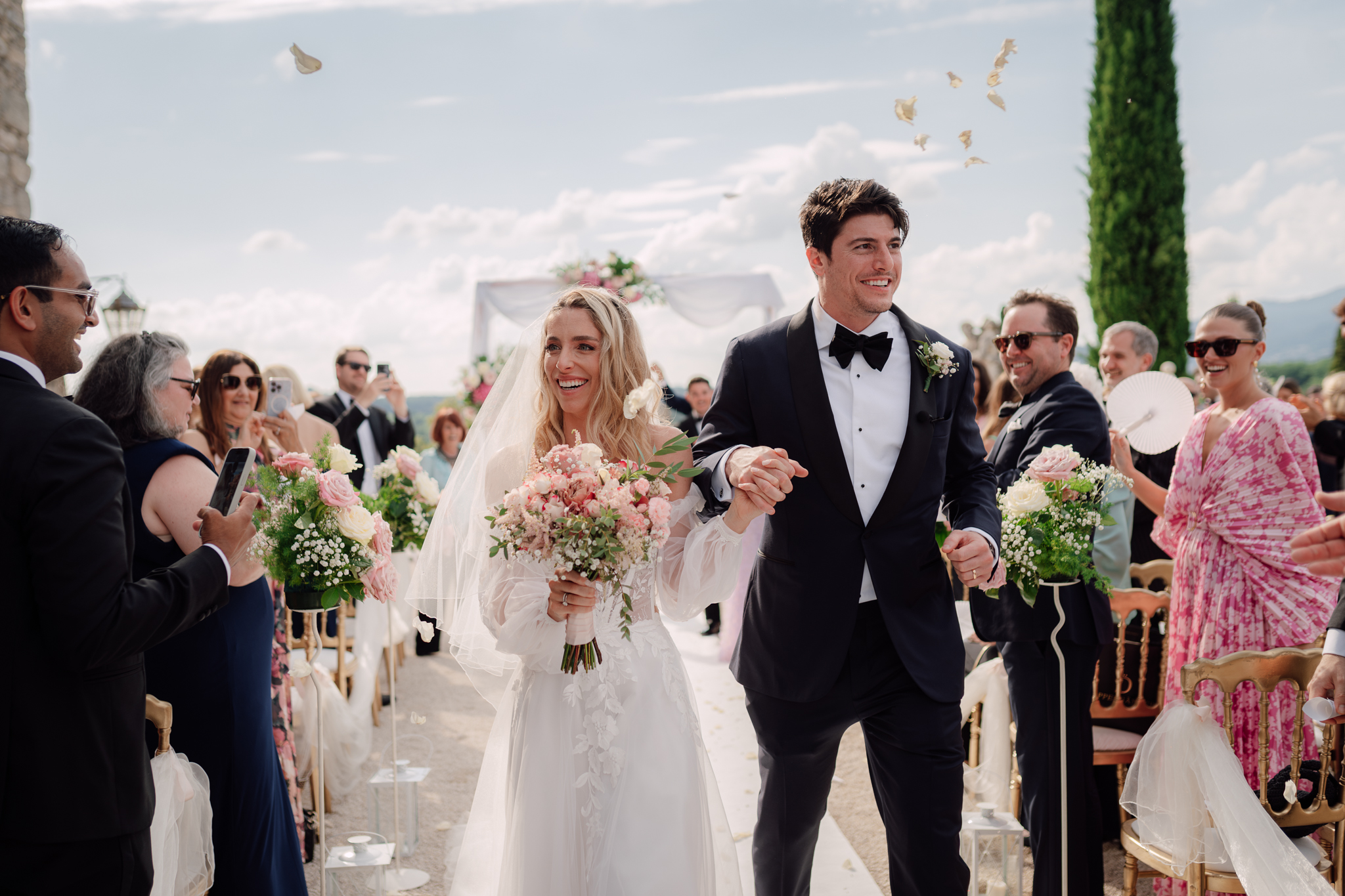 Beatrice e Conrad escono dalla cerimonia accolti da applausi e petali lanciati dagli invitati.