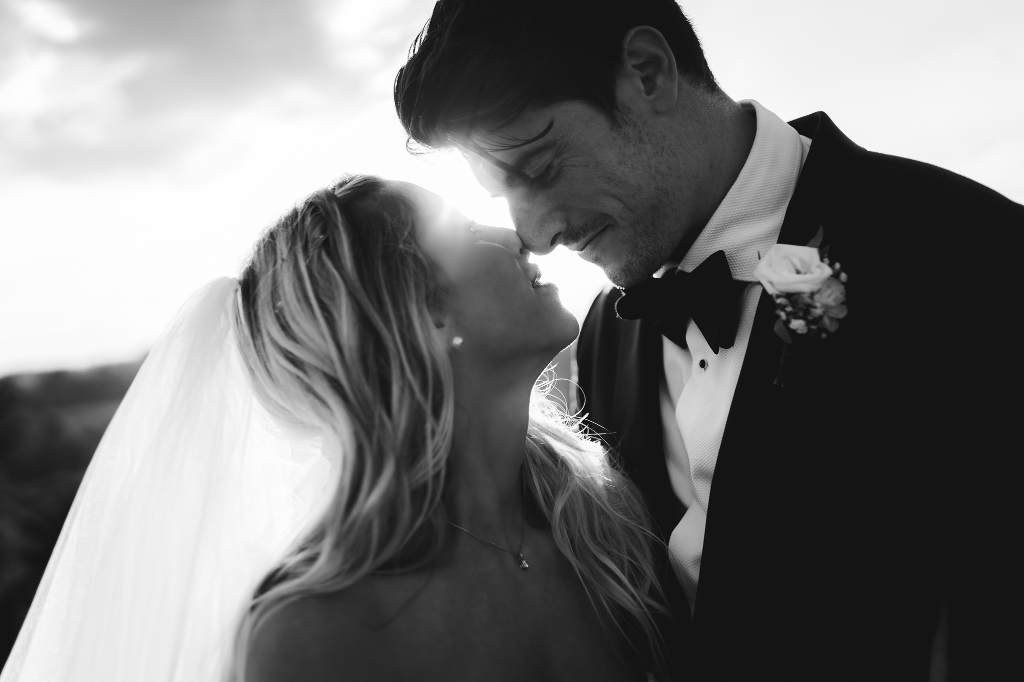 Sposi si guardano negli occhi sorridendo, in controluce.