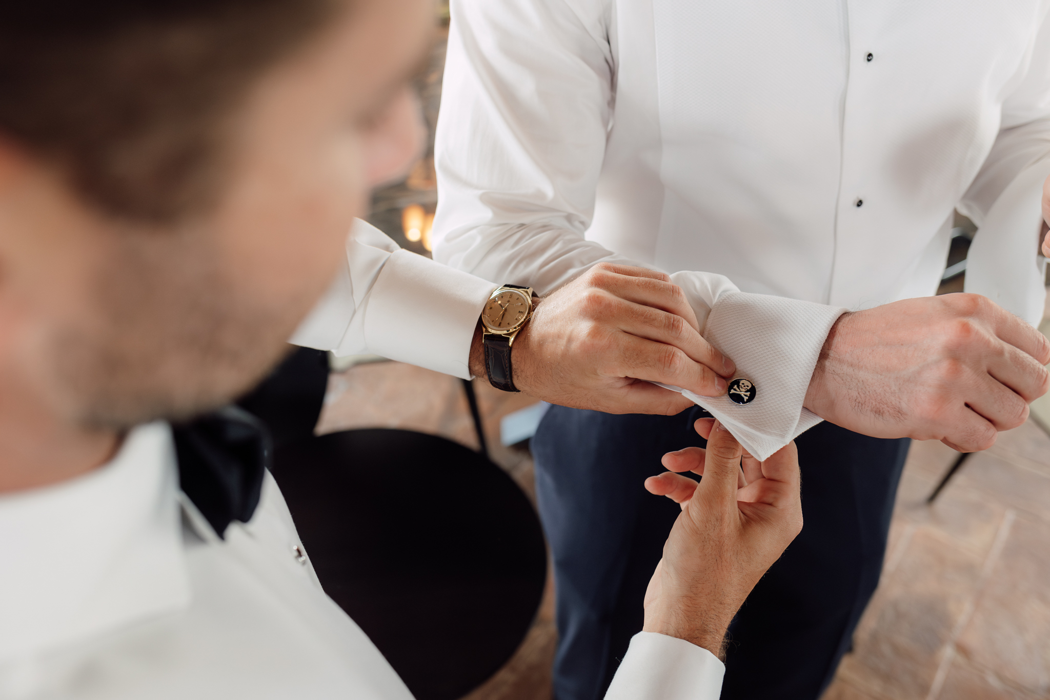 Dettaglio dei gemelli e dell’orologio durante i preparativi dello sposo, simbolo di eleganza e cura nei dettagli.