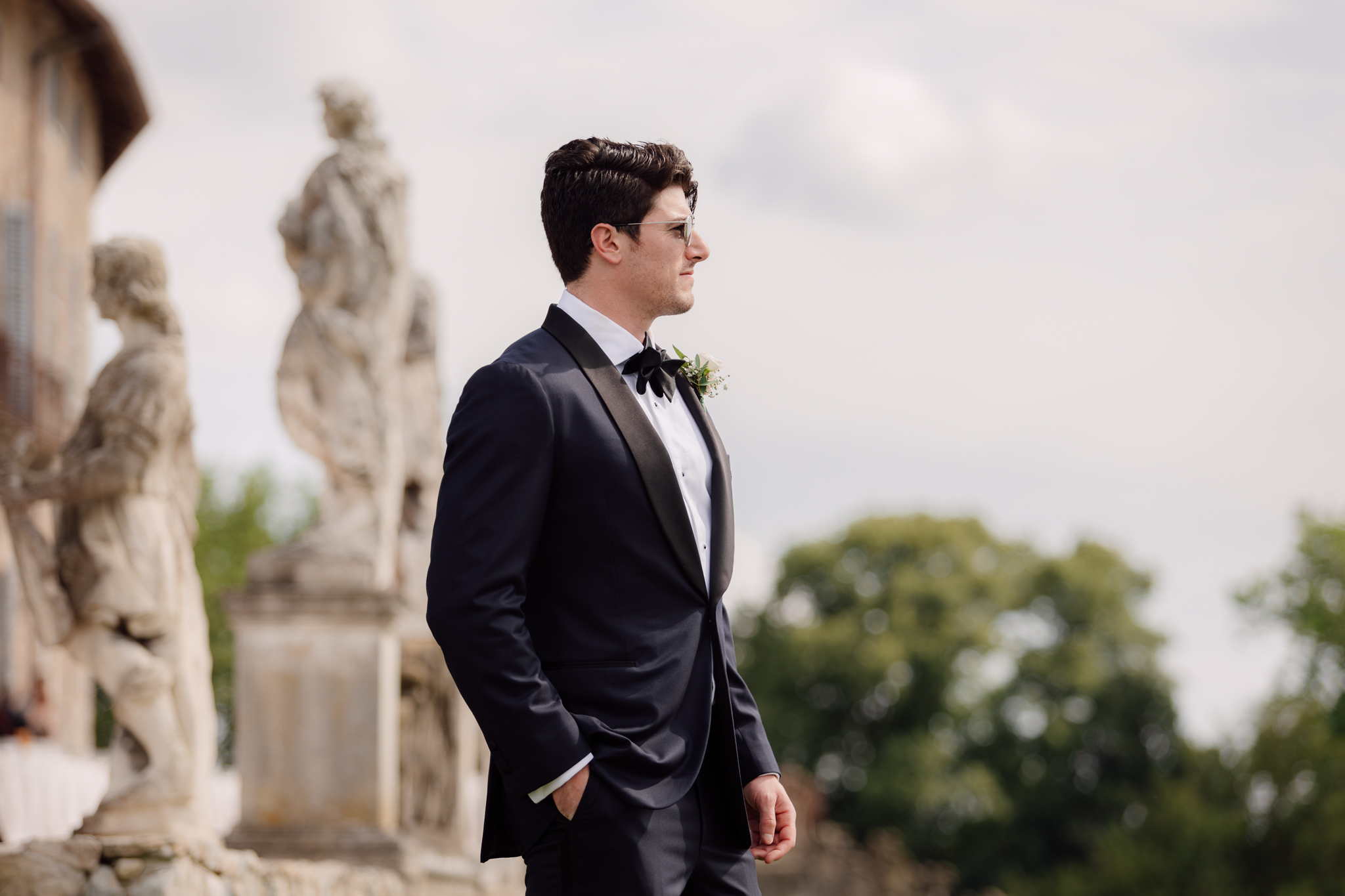 Lo sposo posa con eleganza nel parco della villa, pronto ad accogliere la sua sposa.